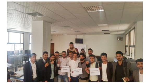 Group of people men a room with some holding posts in their hands